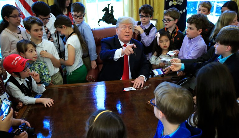 President Donald Trump is surrounded by kids in the Oval Office in celebration of "Bring Our Daughters and Sons to Work Day" at the White House in Washington, Thursday, April 26, 2018.