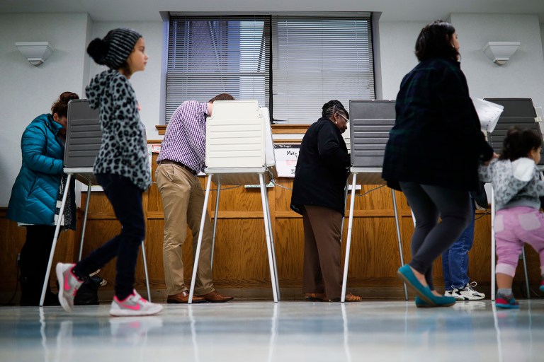 Voters fill out their ballots at the Nativity School polling place on Election Day, Tuesday, Nov. 8, 2016, in Cincinnati. (AP Photo/John Minchillo)