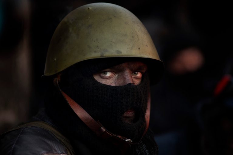 An opposition supporter looks on as he warms himself next to a fire by a barricade near Kiev's Independence Square, the epicenter of the country's current unrest, Ukraine, Friday, Jan. 31, 2014. Ukraine's embattled president Viktor Yanukovych is taking sick leave as the country's political crisis continues without signs of resolution. (AP Photo/Emilio Morenatti)