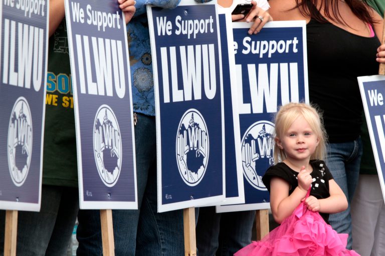 Nicole Williams, the grandaughter of a longshoreman, stands in the midst of ILWU signs in front of Cowlitz County Hall of Justice in Kelso, Wash., in 2011. Workers were involved in a clash with police about a week earlier at a grain terminal in Longview, Wash. (AP Photo/Don Ryan)