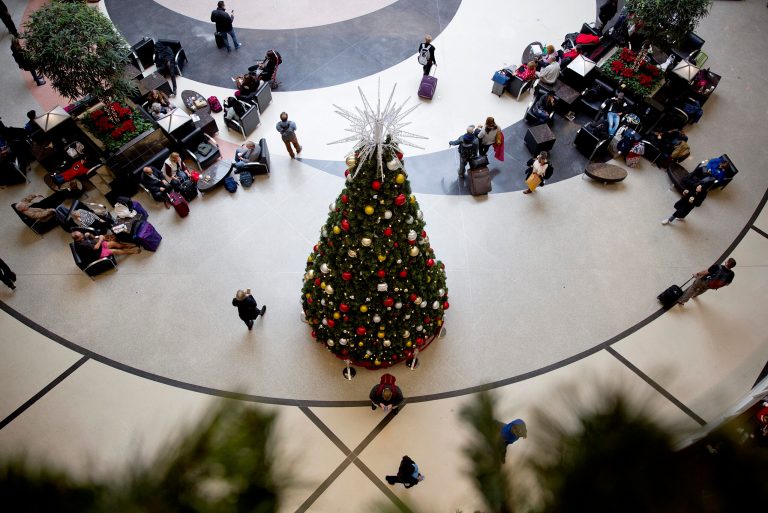 A Christmas tree decorates the atrium where travelers gather while waiting for their flights at Hartsfield-Jackson Atlanta International Airport in Atlanta, Monday, Dec. 18, 2017. While power was restored to the world's busiest airport early Monday, the travel woes will linger for days for the thousands of people stranded at Hartsfield-Jackson Atlanta International, where more than 1,000 flights were grounded just days before the start of the Christmas travel rush. (AP Photo/David Goldman)