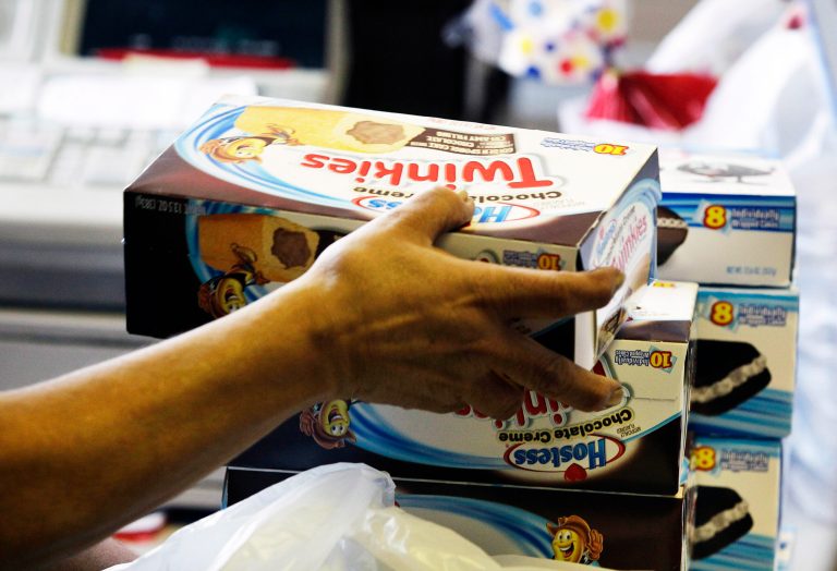   FILE - In this Nov. 16, 2012 file photo, a cashier rings up boxes of Hostess Twinkies and Cup Cakes at the Hostess Brands' bakery in Denver. Blaming a labor dispute for ongoing financial woes, Hostess Brands decided to close shop this year, taking with it lunch box staples such as Twinkies, Ding Dongs and Wonder bread. The company said it would try to sell off its more storied brands, so maybe there is hope for the mysteriously enduring snack cakes. (AP Photo/Brennan Linsley, File)  