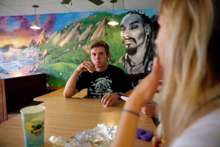 In this photo taken Sept. 23, 2016, college student and former Bernie Sanders supporter Payton Smith, 21, eats lunch at Cheba Hut, a popular sandwich shop for students at the University of Colorado in Boulder, Colo. A new poll finds younger voters overwhelmingly supporting Democrats. (AP Photo/Brennan Linsley)