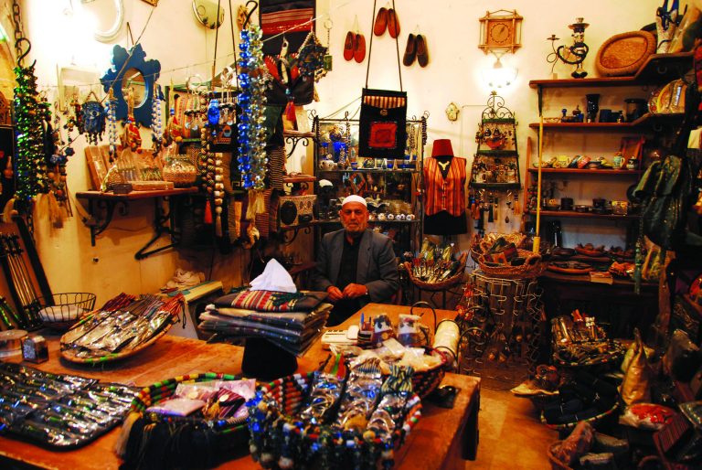 In this picture taken on March 4, 2007, a Syrian vendor sits inside his shop, at the souk in the old city of Aleppo city, Syria. Fires sparked by clashes between government troops and rebels raged through the medieval marketplace of Aleppo on Saturday, Sept. 29, 2012, destroying hundreds of shops lining the vaulted passageways where foods, fabrics, perfumes and spices have been sold for centuries, activists said. (AP Photo/Muzaffar Salman)