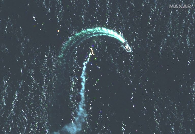 A Russian Serna-class landing ship and a possible missile contrail are seen in the water.