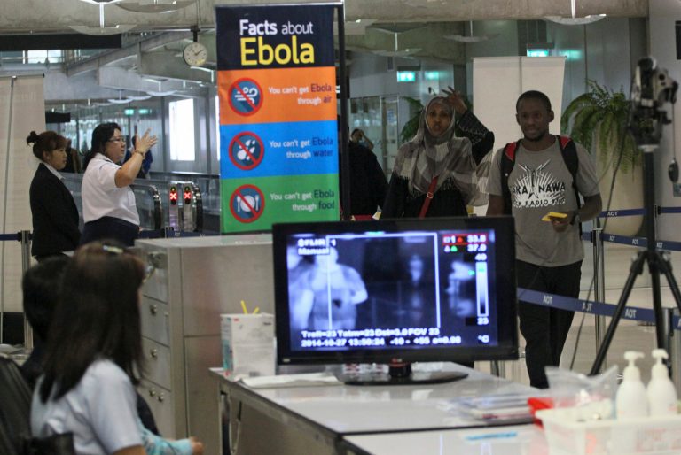 Tourists pass through a thermal scanner at Suvarnbhumi Airport in Bangkok, Thailand, Monday, Oct. 27, 2014 after arriving from Ethiopia. (AP Photo/Sakchai Lalit)