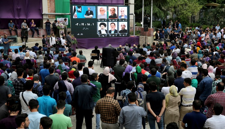 Supporters of Iran's President Hassan Rouhani, who is running for a second term in office, gather to watch a live televised debate outside Rouhani's campaign headquarters in Tehran, Iran, Friday, May 12, 2017. (AP Photo/Ebrahim Noroozi)