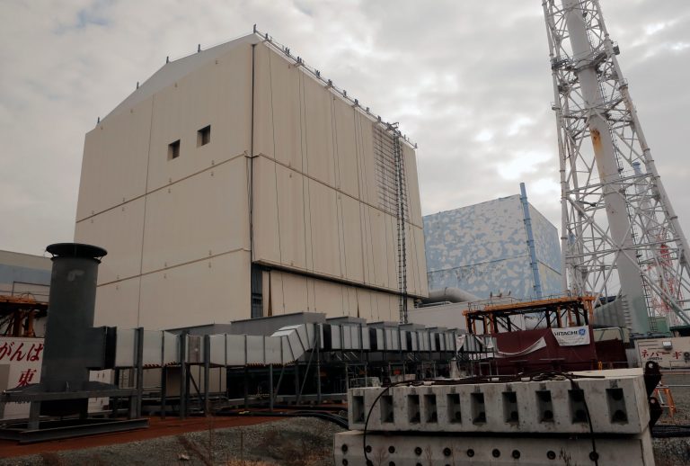FILE - In this Dec. 29, 2012 file photo, the Unit 1 reactor building, left, and Unit 2 of the Fukushima Dai-ichi nuclear power plant are seen through a bus window in Okuma, Fukushima Prefecture, northeastern Japan. Tokyo Electric Power Co. acknowledged in a report Friday that it was not prepared to deal with the earthquake and tsunami that ravaged northeast Japan in March 2011, causing triple-meltdowns at its Fukushima Dai-ichi nuclear plant. (AP Photo/Itsuo Inouye, Pool, File)