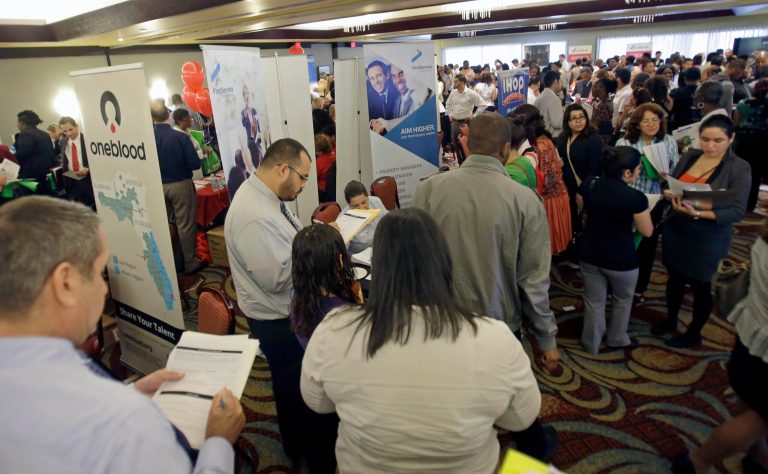 FILE - This Aug. 14, 2013 file photo shows job seekers checking out companies at a job fair in Miami Lakes, Fla. More than 1 million Americans are bracing for a harrowing, post-Christmas jolt as federal unemployment benefits come to a sudden halt this weekend. The development entails potentially significant implications for the recovering U.S. economy and sets up a tense battle when Congress reconvenes in the new year. (AP Photo/Alan Diaz, File)