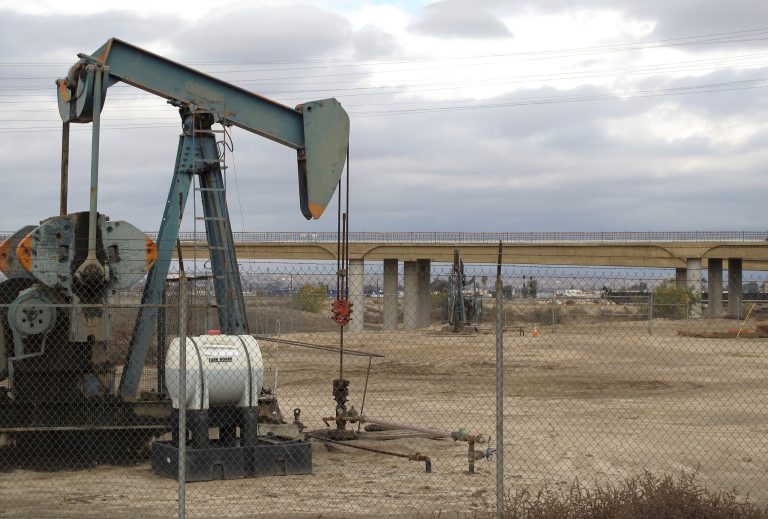   In this Dec. 18, 2012 photo, one of the region's thousands of oil pumps sits in the foreground of the new Westside Parkway under construction in Bakersfield, Calif. Much of the economic boom Bakersfield is enjoying is because high oil prices and new technology for extraction have revived the $10 billion industry that seemed dried up 25 years ago when Kern County set out to diversify its economy and expand its tax base. (AP Photo/Tracie Cone)  