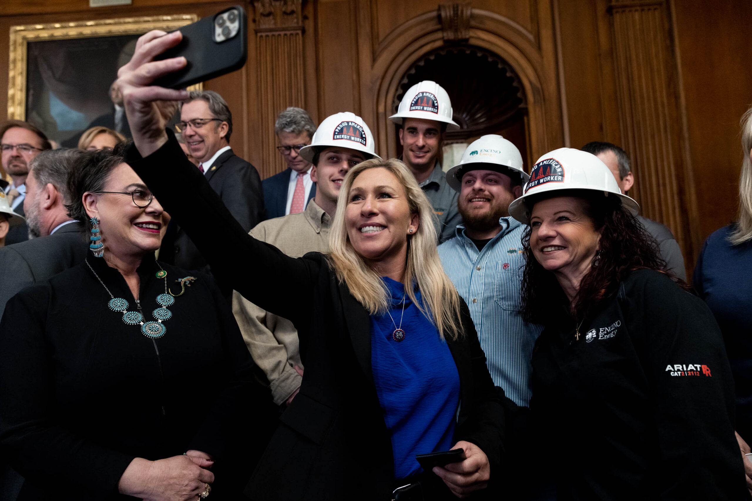 Rep. Marjorie Taylor Greene takes a selfie with energy sector workers at a news conference on the "Lower Energy Costs Act," on Capitol Hill, in Washington, U.S., March 30, 2023.
