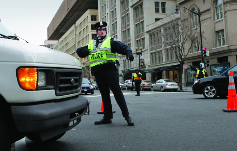 FILE - This Jan. 17, 2009 file photo shows a Washington Metropolitan police officer directing traffic in Washington. From a transportation perspective, Inauguration Day won't be all that different from most regular workdays in the nation's capital: If you want to get downtown on time, you're probably better off not driving. Instead, the hundreds of thousands of people spilling into the city are encouraged to travel by rail, bus or bicycle. And no matter what they choose, they'll eventually end up on foot _ and possibly walking several miles _ to catch a glimpse of President Barack Obama. (AP Photo/Lawrence Jackson, File)