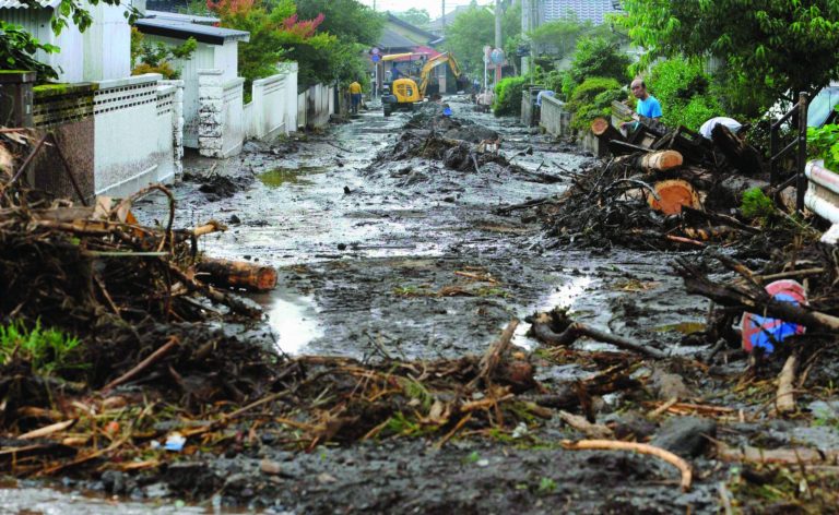 A road is covered with mud and woods carried by a mudslide in Aso, Kumamoto Prefecture, western Japan, Thursday, July 12, 2012. Heavy rains hit southern Japan, triggering flashfloods, mudslides and destroying dozens of homes. (AP Photo/Kyodo News) JAPAN OUT, MANDATORY CREDIT, NO LICENSING IN JAPAN, CHINA, HONG KONG, SOUTH KOREA AND FRANCE