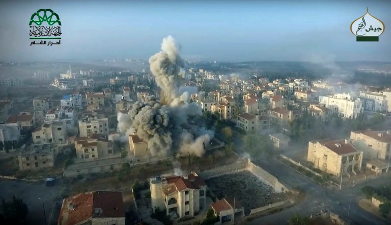 This still image taken from drone footage, posted online by the communications arm of Ahrar al-Sham militant group, purports to show a blast on the ground, apparently the result of an airstrike, in an Assad neighborhood of Aleppo, Syria. (Ahrar al-Sham, militant video, via AP)