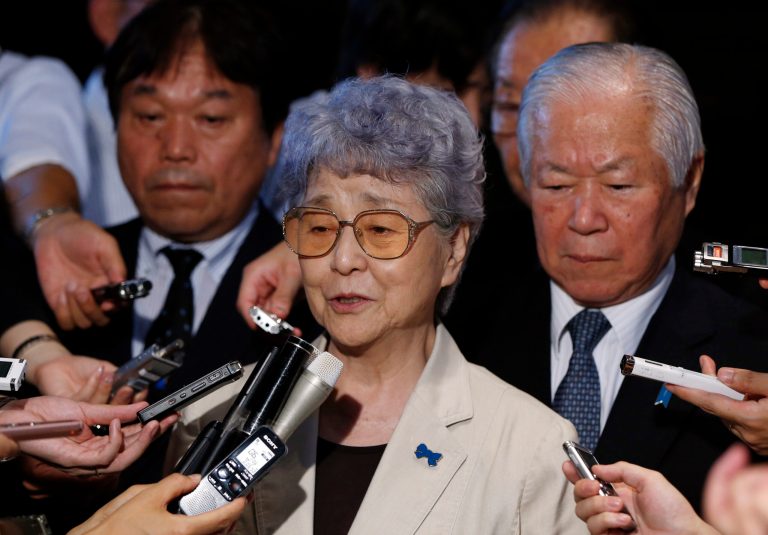 Shigeru Yokota, right, and his wife Sakie, center, parents of a daughter, Megumi who was abducted by North Korean agents in 1977, are surrounded by reporters following their meeting with Japan's Prime Minister Shinzo Abe at Abe's official residence in Tokyo, Friday, July 4, 2014. (AP Photo/Issei Kato, Pool)