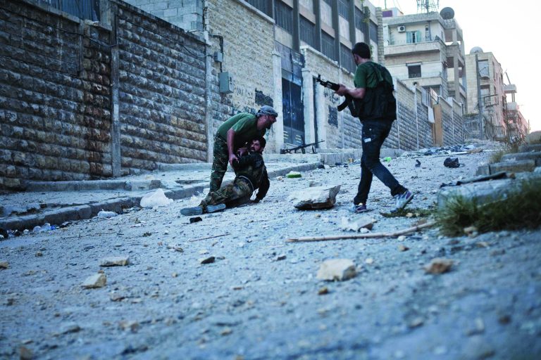 FSA soldiers help a severely wounded colleague after being shot by a Syrian Army sniper in Izaa district in Aleppo, Syria, Saturday, Sept 8, 2012. On Friday, U.S. Senators John McCain, Joe Lieberman and Lindsay Graham, who have toured the volatile Middle East in recent days, urged Washington to help arm Syria's rebels with weapons and create a safe zone inside the country for a transition government. (AP Photo/ Manu Brabo)