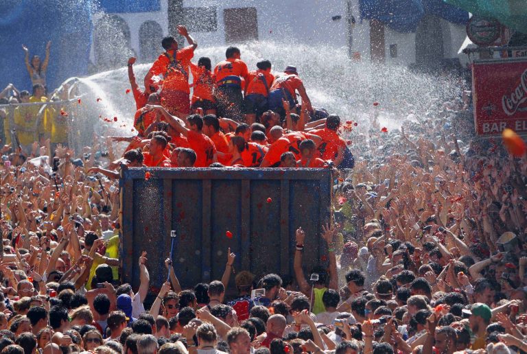 Crowds of people throw tomatoes at each other, during the annual 
