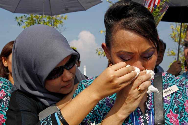 A Malaysia Airlines crew member cries as she waits outside Bunga Raya Complex at Kuala Lumpur International Airport where victims' bodies of the ill-fated Malaysia Airlines Flight MH17 are to be flown back, in Sepang, Malaysia, Friday, Aug. 22, 2014. The bodies and ashes of 20 Malaysians killed when Malaysian Airlines Flight 17 was shot down over Ukraine in July have arrived in Kuala Lumpur. (AP Photo/Lai Seng Sin)