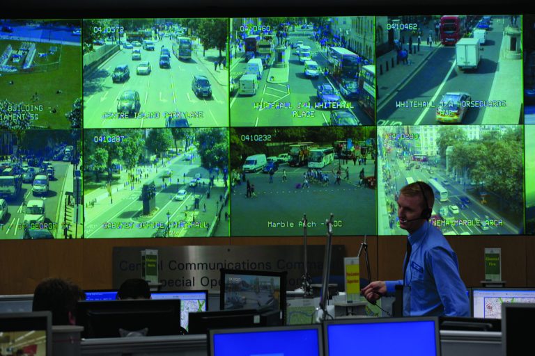 A member of police staff stands in front of CCTV screens in London's Metropolitan Police Service Special Operations Room in central London, Thursday, July 19, 2012. The room will be the police control room for the Olympic Games in the capital and is equipped with technology essential to the smooth running of the policing operation. This includes screens on which CCTV can be shown to provide views across the city. (AP Photo/Matt Dunham)