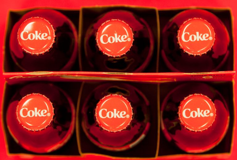 FILE - In this July 15, 2013 file photo, bottle tops of Coca-Cola 8 oz. bottles are photographed in Doral, Fla. The Coca-Cola Co. reports quarterly financial results before the market opens on Tuesday, Feb. 18, 2014. (AP Photo/Wilfredo Lee, File)