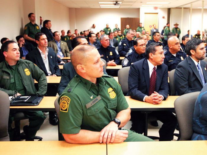 Jason D. Owens, Border Patrol Agent in Charge of the Rio Grande City Station, center, listens to Department of Homeland Security Secretary Jeh Johnson talk about changes in immigration policy at the Border Patrol Station in McAllen, Texas.  (AP Photo/The Monitor, Nathan Lambrecht)