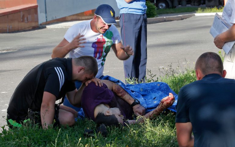 People grieve over the body of their friend, a policeman killed during assault by pro-Russian fighters the Interior Ministry headquarters in downtown Donetsk, eastern Ukraine Tuesday, July 1, 2014.  The rebels captured the Interior Ministry headquarters in a major city after an hours-long gun battle, a day after the president said rebels weren't serious about peace talks and ended a cease-fire. (AP Photo/Dmitry Lovetsky)