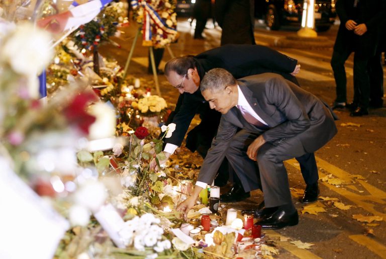 President Barack Obama and French President Francois Hollande pay their respects at the memorial outside the Bataclan in Paris on November 30. (SIPA via AP)