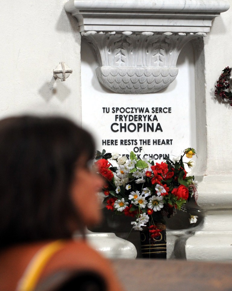 FILE - In this July 28, 2008 file photo a woman sits in front of the shrine where the heart of Polish-born composer Frederic Chopin rests in the Church of the Holy Cross, in Warsaw, Poland. Polish medical experts say Wednesday, Sept. 17, 2014, that the preserved heart of 19th century composer shows signs of tuberculosis and possibly some other lung disease. The findings seem to corroborate Chopin's 1849 death certificate which said that the Polish-born musician died at the age of 39 in Paris from TB. (AP Photo/Alik Keplicz, File)