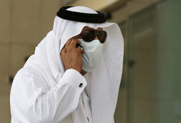 FILE - In this Friday, May 9, 2014 file photo, a Saudi man talks on his phone as he wears a mask outside King Fahd Hospital in Jeddah, Saudi Arabia. Saudi health officials say another five people have died after contracting a potentially fatal Middle Eastern respiratory virus that has sickened hundreds. (AP Photo/Hasan Jamali, File)