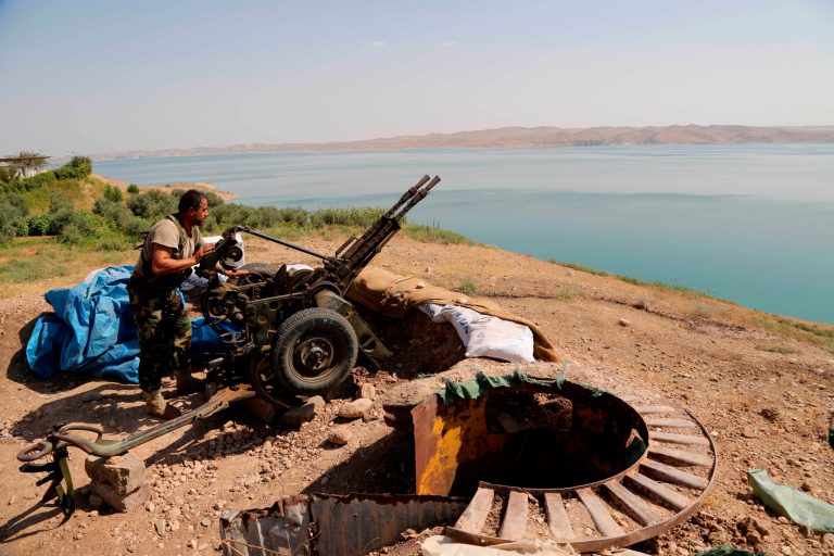 A Kurdish peshmerga fighter prepares his weapon at his combat position near the Mosul Dam at the town of Chamibarakat outside Mosul, Iraq, Sunday. (AP/Khalid Mohammed)