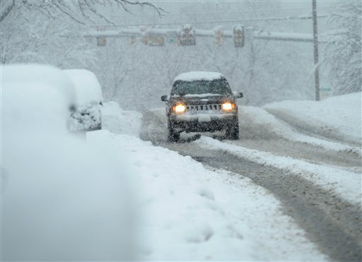An SUV travels through the falling snow on Frontier Drive in Staunton, Va., on Wednesday. (AP Photo/The Daily News Leader, Mike Tripp) 