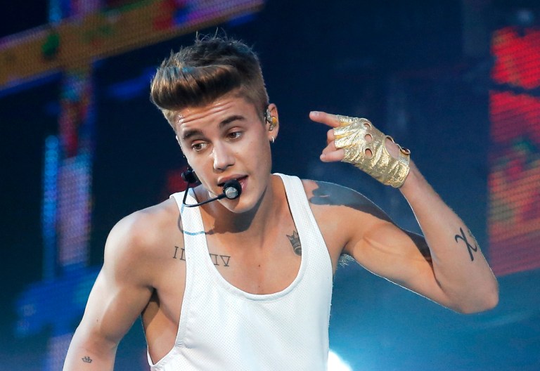FILE - In this March 19, 2013 file photo, Justin Bieber performs during a concert at Bercy Arena in Paris. Bieber has apologized to those he offended by visiting Japan's Yasukuni war shrine the week of April 20, 2014, saying he was misled to see it as only a place of prayer. The Shinto shrine in Tokyo honors 2.5 million war dead, including 14 convicted war criminals. China and South Korea in particular see Yasukuni as a symbol of Japan's past militarism and see visits to it as a lack of understanding or remorse over wartime history. (AP Photo/Francois Mori, File)
