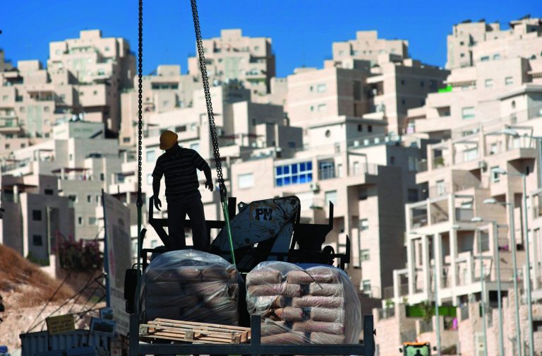 FILE - In this Nov. 2, 2011 file photo, a construction worker works on a new housing unit in the east Jerusalem neighborhood of Har Homa. Israel is planning its biggest construction surge in east Jerusalem in decades, settlement opponents say, a move that would complicate prospects for restarting peace talks with the Palestinians. With more than 9,000 apartments in the pipeline, Prime Minister Benjamin Netanyahu is reaffirming his opposition to ceding any parts of the holy city to the Palestinians, who say there can be no peace accord without partitioning the holy city.(AP Photo/Sebastian Scheiner, File)