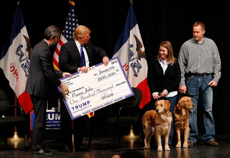 Republican presidential candidate Donald Trump handed out a $100,000 check to the Puppy Jake Foundation during the last of his three events in eastern Iowa. (AP Photo/Paul Sancya)