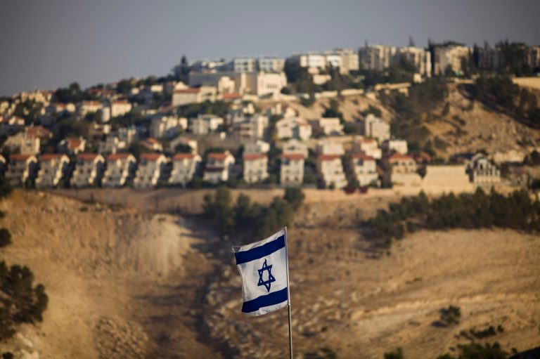 In this Monday, Sept. 7, 2009 file photo, an Israeli flag is seen in front of the West Bank Jewish settlement of Maaleh Adumim on the outskirts of Jerusalem. (AP Photo/Bernat Armangue, File)