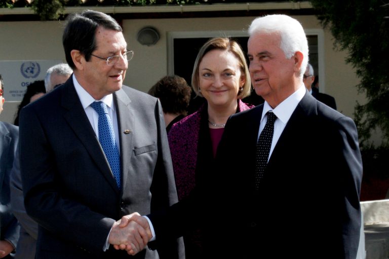 Cyprus president Nicos Anastasiades, left, and Turkish Cypriot leader Dervis Eroglu shake hands as U.N. Secretary-General's Special Representative to Cyprus Lisa Buttenheim, center, smiles after their meeting at a UN compound in the UN buffer zone in the divided capital Nicosia, Cyprus, Tuesday, Feb. 11, 2014. The leaders of Cyprus' Greek and Turkish Cypriot communities are embarking on a new round of talks aimed at achieving the long-elusive goal of reunifying the ethnically split island nation. (AP Photo/Petros Karadjias)