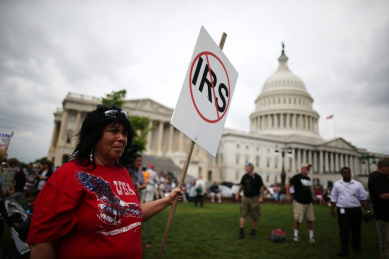 Nancy Riordan holds a sign while participating in a Tea Party rally at the U.S. Capitol, June 19, in Washington.  (Photo by Mark Wilson/Getty Images)