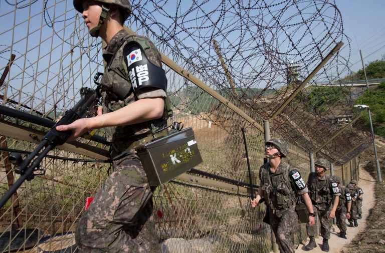 South Korean army soldiers patrol along the barbed-wire fence at the demilitarized zone (DMZ) in Cheorwon, South Korea, Tuesday, May 13, 2014. North Korea warned Tuesday that a South Korean official would pay a high price for saying the North 
