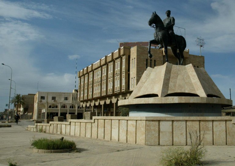 In this Sunday, April 13, 2003 file photo, a statue of Iraqi President Saddam Hussein is seen as the streets are nearly deserted in central Tikrit, Iraq. Backed by allied Shiite and Sunni fighters, Iraqi security forces on Monday began a large-scale military operation to recapture Saddam Hussein's hometown from the Islamic State extremist group, state TV said, a major step in a campaign to reclaim a large swath of territory in northern Iraq controlled by the militants. (AP Photo/Kevin Frayer, File)