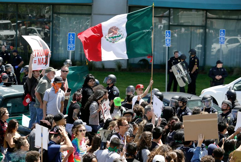 A protester against Republican presidential candidate Donald Trump waves a flag of Mexico. A former top Mexican official dismissed reports that Mexicans are returning home. (AP Photo/Eric Risberg)