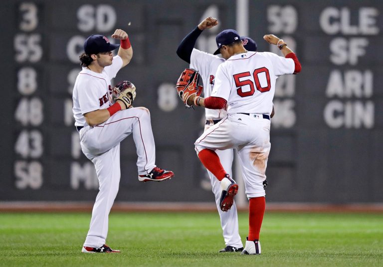 Boston Red Sox left fielder Andrew Benintendi, left, right fielder Mookie Betts (50) and center fielder Jackie Bradley Jr. celebrate after defeating the Toronto Blue Jays in a baseball game at Fenway Park in Boston, Wednesday, July 19, 2017. The Red Sox won 5-1. (AP Photo/Charles Krupa)