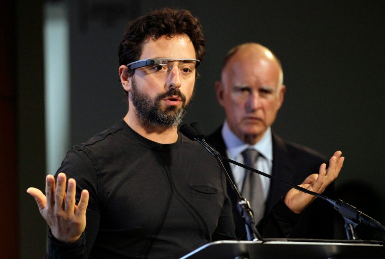 FILE - In this Sept. 25, 2012 file photo, Google co-founder Sergey Brin, left, wearing Google Glass, speaks as California Gov. Jerry Brown, right, listens during a bill signing for driverless cars at Google headquarters in Mountain View, Calif. Despite Brin's and other tech entrepreneurs' frustration with the complex web of federal rules governing health care, their industry continues pouring money into efforts to reshape the $2.7 trillion dollar sector that has been largely untouched by the innovations of Silicon Valley. (AP Photo/Eric Risberg, File)