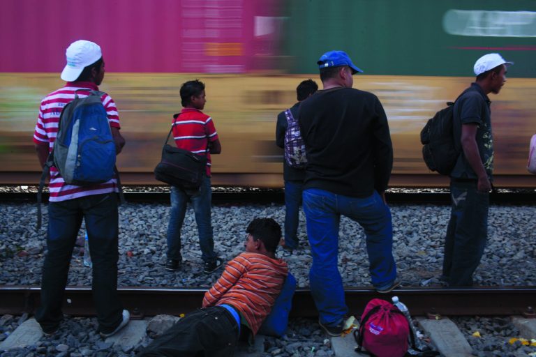 In this May 17, 2012 photo, migrants, mostly from Honduras, watch a southbound train pass by as they wait for one going north, in Lecheria, on the outskirts of Mexico City. While the number of Mexicans heading to the U.S. has dropped dramatically, a surge of Central American migrants is making the 1,000-mile northbound journey this year, fueled in large part by the rising violence brought by the spread of Mexican drug cartels. (AP Photo/Alexandre Meneghini)