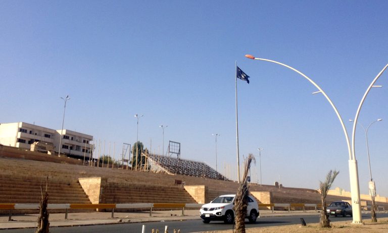 A black flag used by the al-Qaida inspired Islamic State of Iraq and the Levant (ISIL) waves over the celebrations square in the northern city of Mosul, Iraq, Tuesday, July 1, 2014. The militant extremist group's unilateral declaration of an Islamic state is threatening to undermine its already-tenuous alliance with other Sunnis who helped it overrun much of northern and western Iraq. (AP Photo)