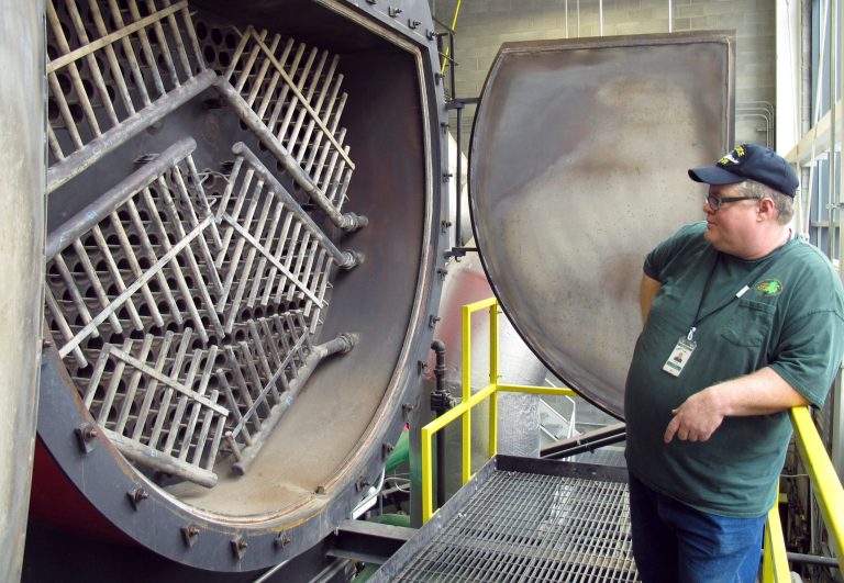 Heating plant supervisor Daniel McLaughlin looks into the fire tube section of a wood-chip-fired boiler Tuesday, Sept. 30, 2014, that will produce steam and hot water to heat state offices and some city buildings in Montpelier, Vt. The $23 million heating system is part of a project to make Montpelier 
