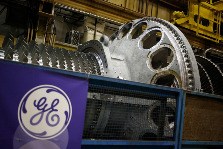 A logo is displayed next to a gas turbine at the GE energy plant in Greenville, S.C. GE's power-generation business has struggled in the past year as markets wilted following the company's $10 billion investment in Alstom's grid operation. Photographer: Luke Sharrett/Bloomberg