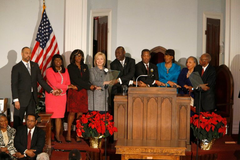 Democratic presidential candidate Hillary Clinton joins hands to sing 