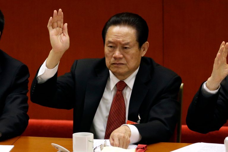 HOLD FOR USE WITH CHINA ANATOMY OF A TAKEDOWN   
In this photo taken Wednesday Nov. 14, 2012, Zhou Yongkang then Chinese Communist Party Politburo Standing Committee member in charge of security, raises his hand to show approval for a work report during the closing ceremony for the 18th Communist Party Congress at the Great Hall of the People in Beijing, China. Chinaâs ruling Communist Party has announced July 29, 2014 an investigation into the former security chief Zhou Yongkang, a move that usually paves the way for criminal prosecution.  (AP Photo/Lee Jin-man)