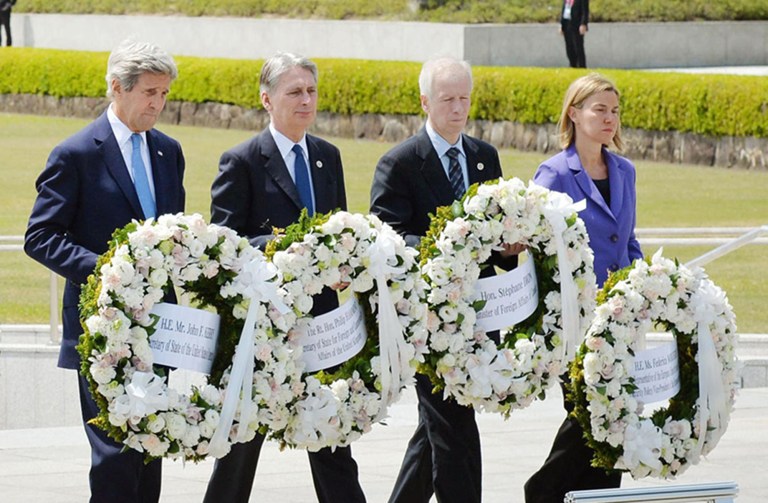 U.S. Secretary of State John Kerry, Britain's foreign minister, Canada's foreign minister and E.U. High Representative for Foreign Affairs carry a wreath to offer at the cenotaph at Hiroshima Peace Memorial Park in Hiroshima, Japan. (Kyodo News via AP)