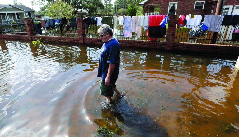 Peter Roccaforte walks through floodwaters from Hurricane Isaac at his home in Reserve, La., as some of his clothing hangs out to dry Saturday, Sept. 1, 2012. Floodwaters cover many streets and power remains out in some areas. Louisiana's Public Service Commission said more than 443,000 customers remained without electricity around Louisiana on Saturday morning, days after Hurricane Isaac crept across the state. (AP Photo/David J. Phillip)